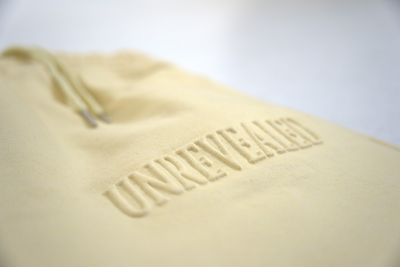 "UNREVEALED" Embossed Sweatpants (TAN)